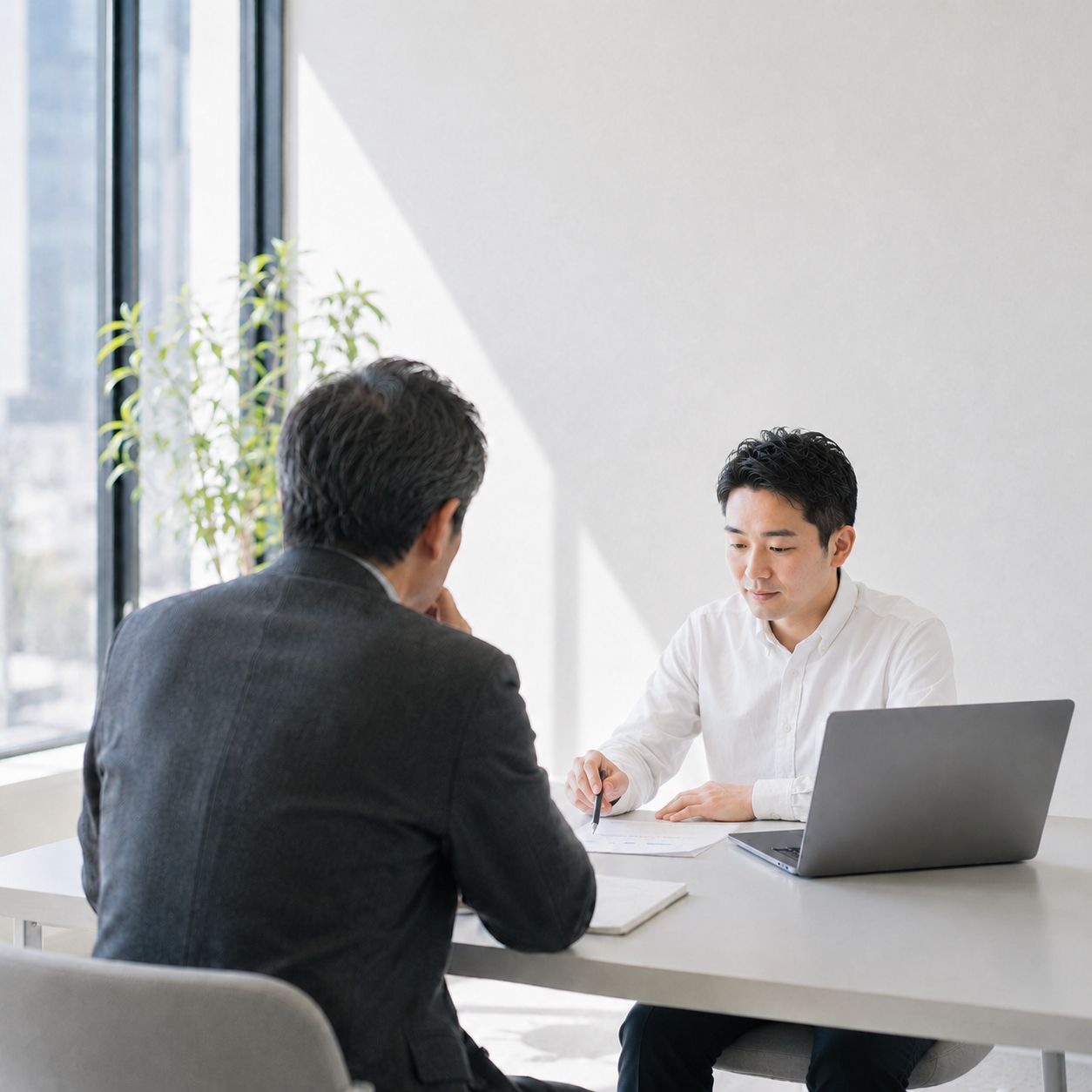 相談者と向き合い、資料を見ながら話すエンジニア